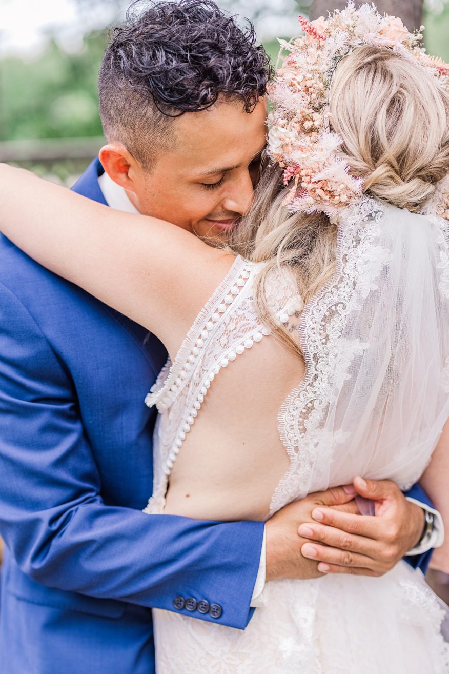 latino groom hugging his bride during a first look